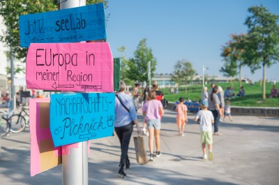 Improvisierter Wegweiser, der am Hannah-Arendt-Platz steht, und beim Straßenfest 2020 zur Orientierung diente.