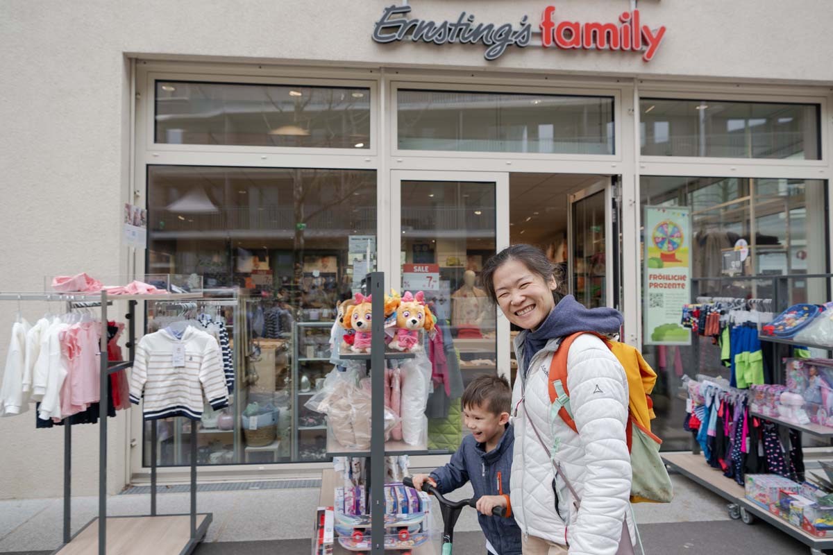 Eine Mutter mit einem Kind vor dem Shop von Ernstings Famliy in der Seestadt. 