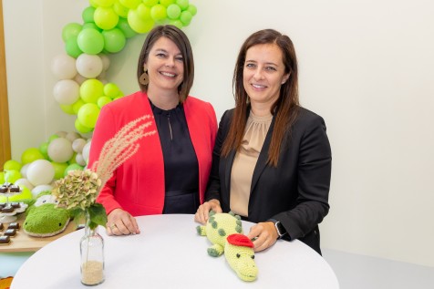 Zwei Frauen an einem Stehtisch vor grünen Ballons